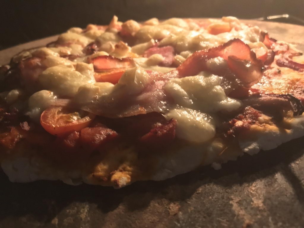 Pizza mit frischen Tomaten Bacon und Käse
