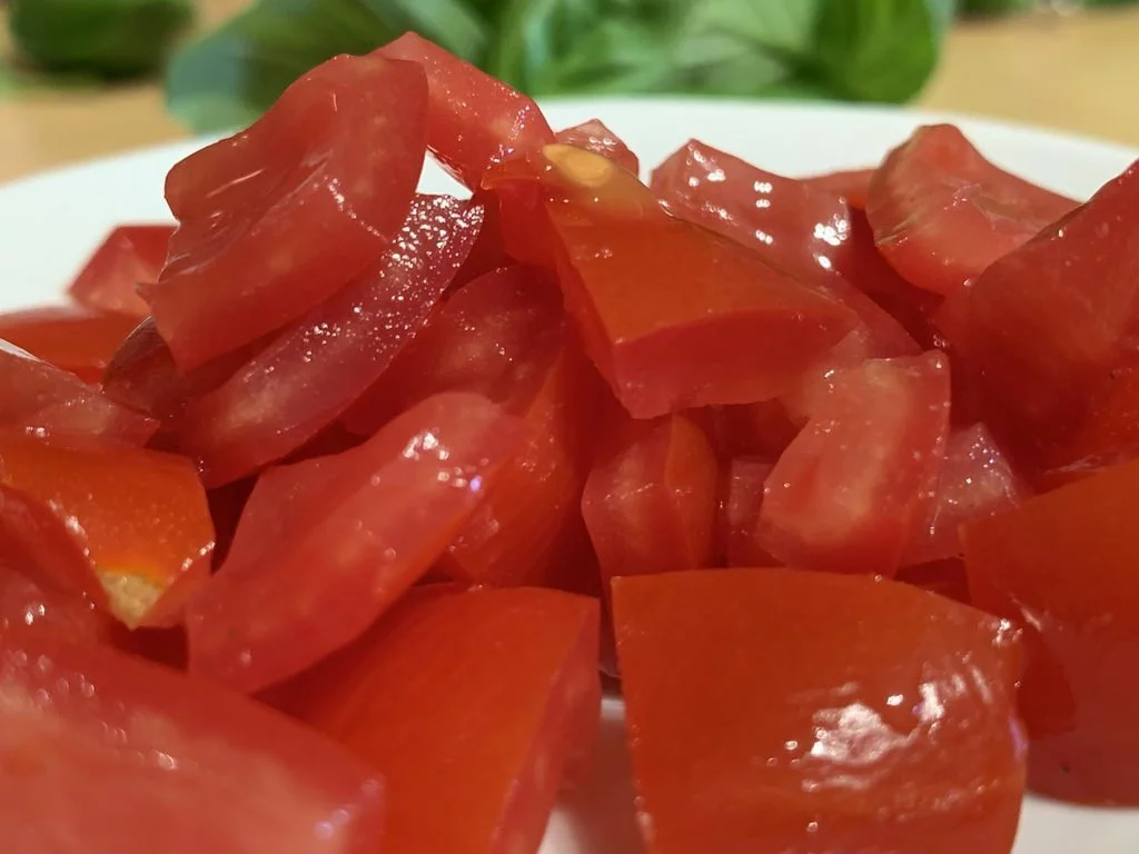Ravioli mit Wurstfüllung an Basilikumbutter - entkernte Tomaten