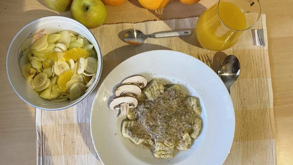Pilz-Gnocchi mit Champignon-Rahmsauce und Obstsalat - serviert